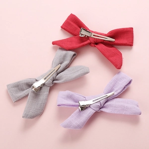 Three-piece set of cotton bow hair clips in red, grey, and lilac with metal duckbill clips