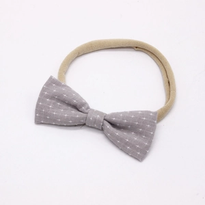 Close-up of baby headband featuring a grey star pattern cotton bow and elastic nylon band