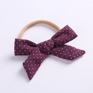 Detail of purple cotton bow headband with white stars and soft nylon band for babies