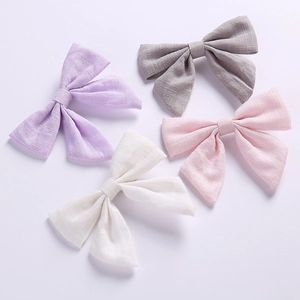 Lot de quatre barrettes à cheveux en lin avec nœuds papillon en couleurs pastel