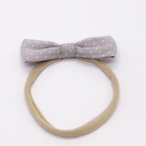Detail of grey cotton bow headband with white star pattern and elastic band for babies