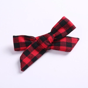 Gros plan sur la barrette nœud à carreaux rouge et noir avec texture tissée en coton