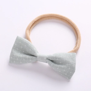 Detailed texture of cotton linen baby headband with small white cross pattern bow