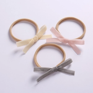 Three-piece infant velvet bow headbands in cream, pink and grey on soft nylon elastics
