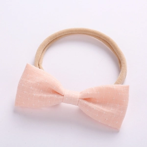 Detail of pink cotton bow headband with white star patterns and soft nylon elastic band