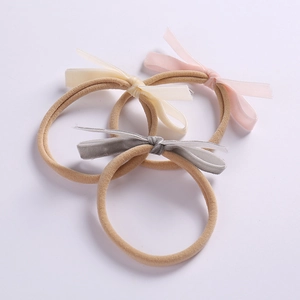 Three-piece set of velvet bow headbands for infants in pink, off-white, and grey colors