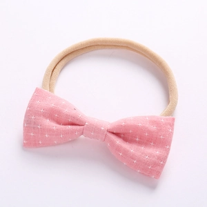 Detail view of baby bow headband with pink cross pattern and soft nylon band