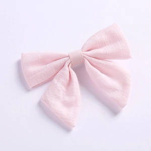 Gros plan détaillé montrant la texture du lin rose du nœud papillon pour les filles