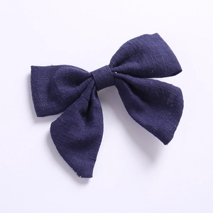 Détail de la texture d'un nœud papillon en lin bleu marine pour cheveux de filles