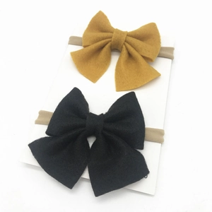 Two-pack baby nylon headbands with large fabric bows in ginger yellow and black colors