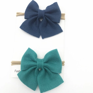 Detail of baby nylon headbands with oversized wool felt bows in navy and teal green