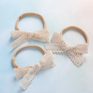 Set di tre fasce per neonati con fiocchi in pizzo color crema ed elastico in nylon