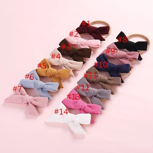 Flat lay of 14 colorful corduroy bow headbands with elastic nylon bands for baby girls