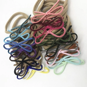 Mise à plat de nœuds en velours colorés sur bandeaux élastiques en nylon pour bébés