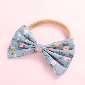 Détail du bandeau pour bébé avec nœud floral en coton bleu clair et nylon souple