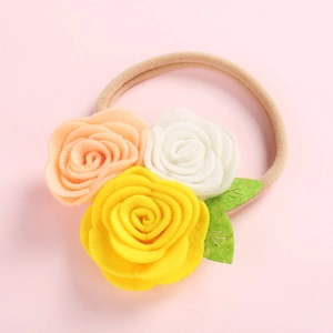 Détail de roses en feutrine faites main sur un bandeau en nylon doux pour bébés