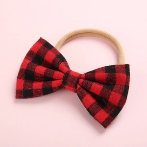 Détail du nœud à carreaux rouge et noir sur un bandeau souple en nylon pour bébé