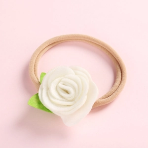 Détail d'un bandeau rose pour bébé avec fleur de rose en feutre blanc et petites feuilles
