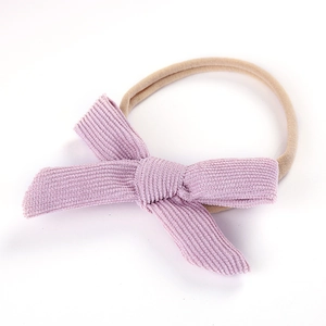 Detail of baby headband featuring a light purple corduroy bow and soft nylon band