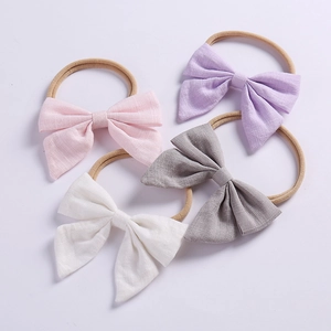 Detail of 4-pack linen bow headbands with soft nylon elastic bands for baby girls