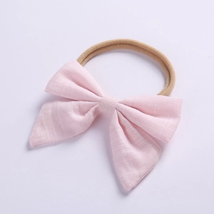 Detailed view of pink linen bow baby headband with high-elastic seamless nylon strap
