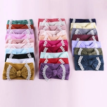 Flat lay of soft elastic baby headbands with large bows and delicate lace trim in various colors