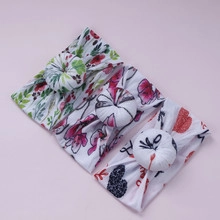 Detailed view of three baby nylon headbands with floral and love prints on purple background