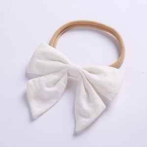 Close-up of white linen bow baby headband with soft seamless nylon elastic band for infants