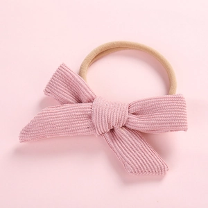 Detailed view of pink corduroy bow texture on a soft high-elastic nylon baby headband