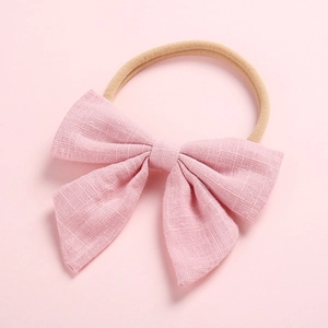 Close-up of soft pink linen cotton bow headband with elastic nylon band for baby girls