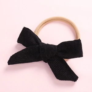 Detailed view of a black corduroy bow baby headband with elastic stretchy band