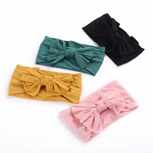 Lot de quatre bandeaux en nylon souple pour bébé avec grands nœuds en plusieurs couleurs