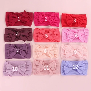 Set of 12 soft elastic baby headbands with large bows in various pink and purple hues