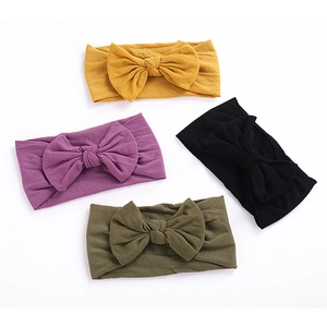 Detailed view of four soft nylon elastic baby headbands with large bow knots in various colors
