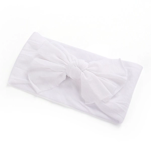 Détail d'un bandeau large en nylon blanc avec un grand nœud fait main pour bébé