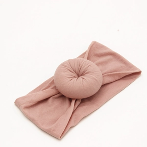 Close-up of baby nylon headband with a soft donut knot in a dusty rose pink finish