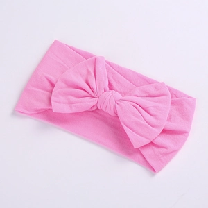 Detailed close-up of pink nylon baby headband with a large decorative bow tie