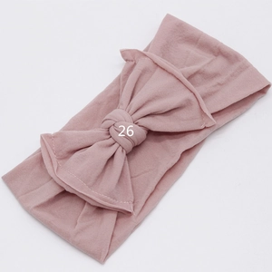 Macro detail of the soft elastic dusty rose baby headband with a large tied bow