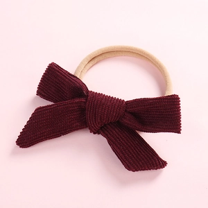 Close-up of wine red corduroy bow with high elasticity nylon band for newborns