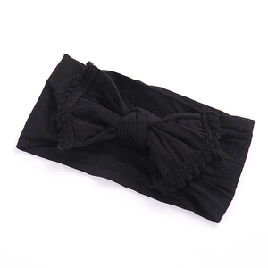 Close-up of black wide elastic nylon headband with a large bow for babies and children