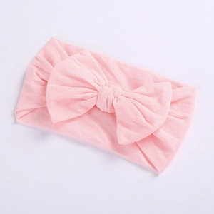 Detail of soft pale pink nylon headband with a large bow for baby girls and infants