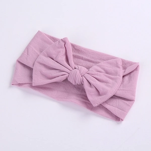 Close-up of baby nylon headband with a large lavender purple knit bow for infants