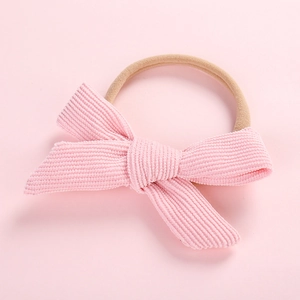 Detail of pink corduroy bow and beige high-elastic headband for newborn baby girls