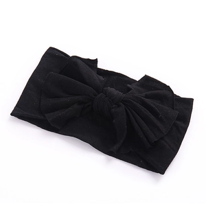 Vue détaillée du bandeau avec nœud noir fait main sur tissu en nylon extensible doux