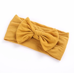 Detailed texture of ginger yellow nylon headband with a large decorative bow