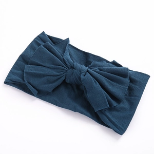 Détail d'un bandeau souple bleu marine pour bébé avec un grand nœud en tissu fait main