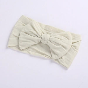 Detail of soft elastic nylon baby headband featuring a large cream white bow knot