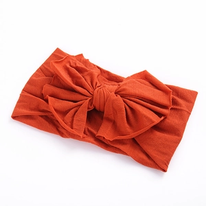 Bandeau souple en nylon orange brûlé pour bébés avec un grand nœud décoratif sur le dessus