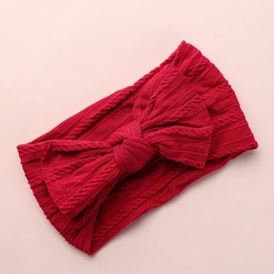Macro shot of red cable knit pattern and large bow detail on baby headband