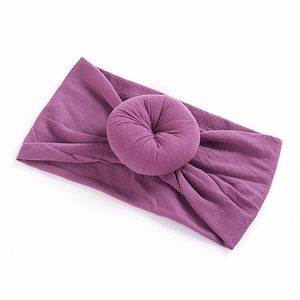 Detailed close-up of a lilac elastic nylon headband with a sweet donut-shaped knot for babies
